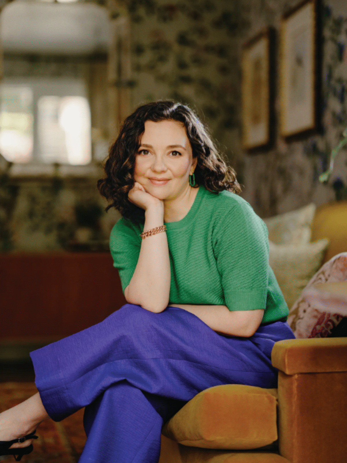 Cari Tuna sits on a chair and smiles